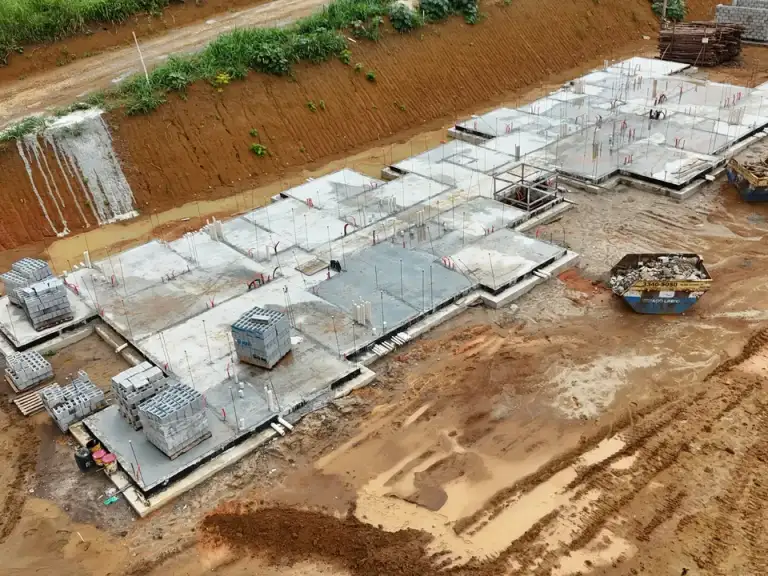 Vista aérea de fundações de edificação em terreno em preparação.
