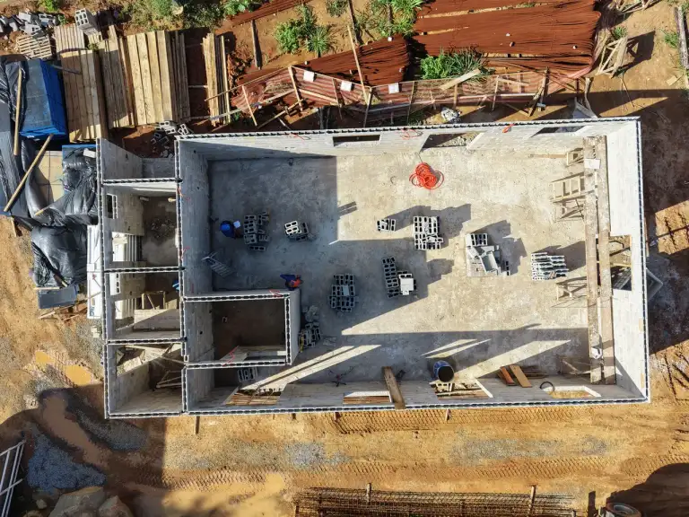 Vista aérea de laje de concreto com ferragem exposta em edificação em construção.