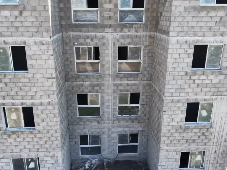 Sobrevoo aéreo de conjunto habitacional em construção.